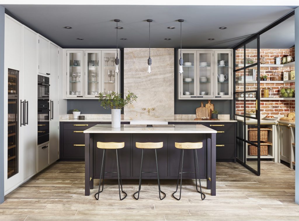 Tillingham shaker style kitchen with a dark blue island and wooden stools